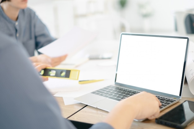 PSD mockup image of engineers using laptop to drawing design building project in office