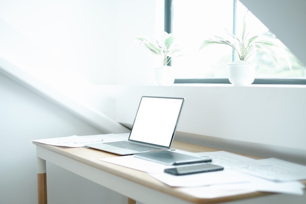 Mockup image of laptop on wood table with equipment of the mobile application graphic designer