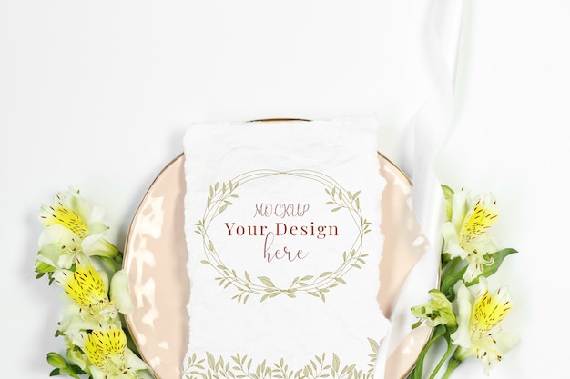 Mockup invitation card with flowers on pink plate