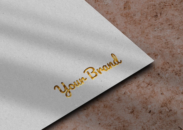 Mockup met gouden logo in reliëf op wit papier premium psd