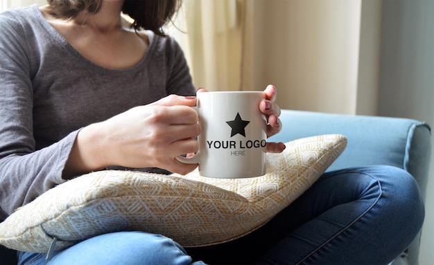 PSD mockup for mug grabbed by hand on cozy ambience