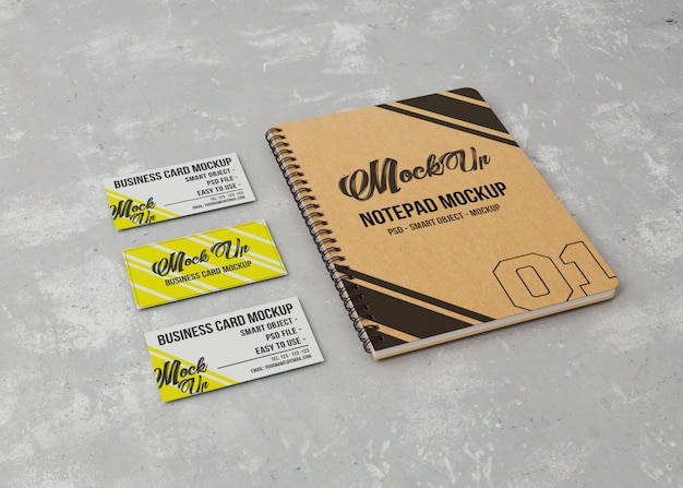 Blocco note mockup e tre biglietti da visita