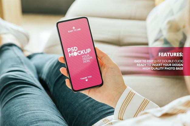 Mockup of a phone held by a woman sitting on the couch