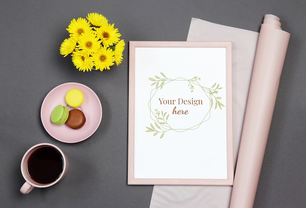 Mockup photo frame with yellow bouquet, cup of coffee and macaron on black background