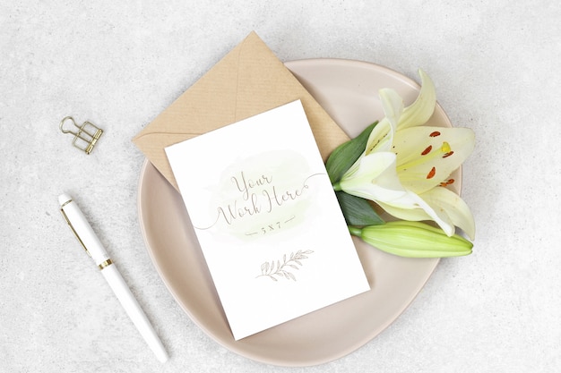 Mockup uitnodigingskaart met witte pen en bloemen