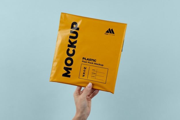 PSD mockup van plastic postpakket in handen gehouden