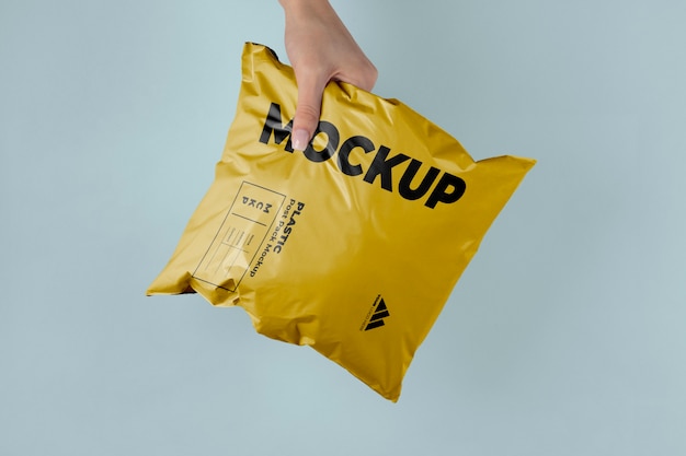 PSD mockup van plastic postpakket in handen gehouden