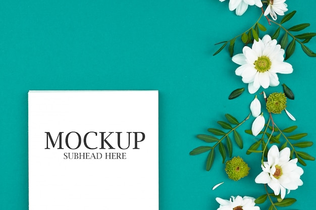 PSD mockup van witte notebook en chrysant bloemen