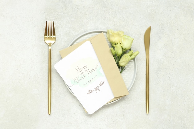 PSD mockup wedding invitation card on plate and gold cutlery