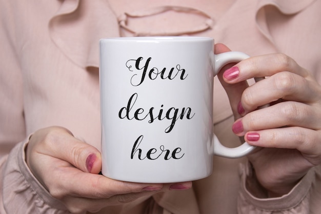 PSD mockup of a white ceramic coffee mug in hands