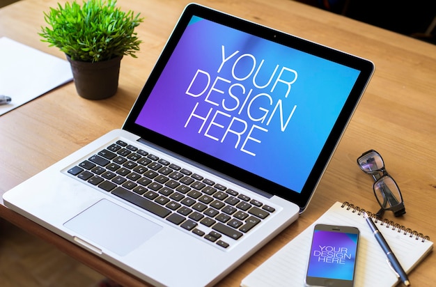 Mockups voor laptop en mobiele telefoon op kantoortafel