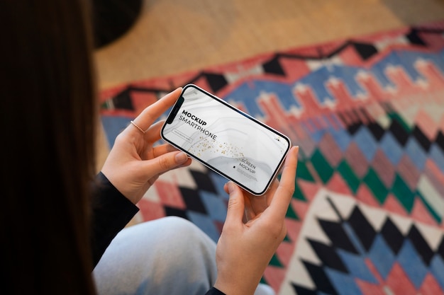 Model holding a smartphone mockup