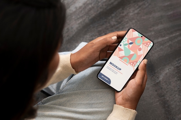 PSD モデルがスマートフォンを握っているモックアップ
