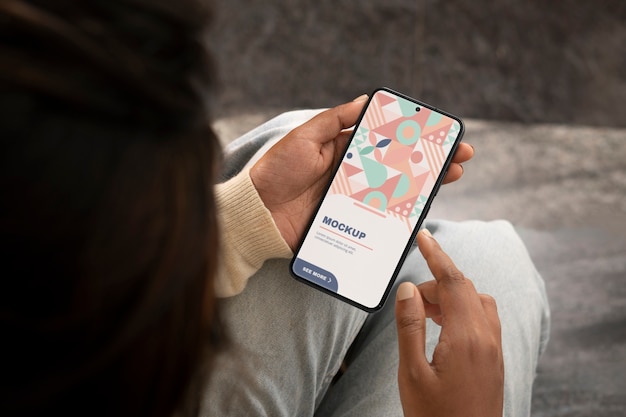 PSD モデルがスマートフォンを握っているモックアップ
