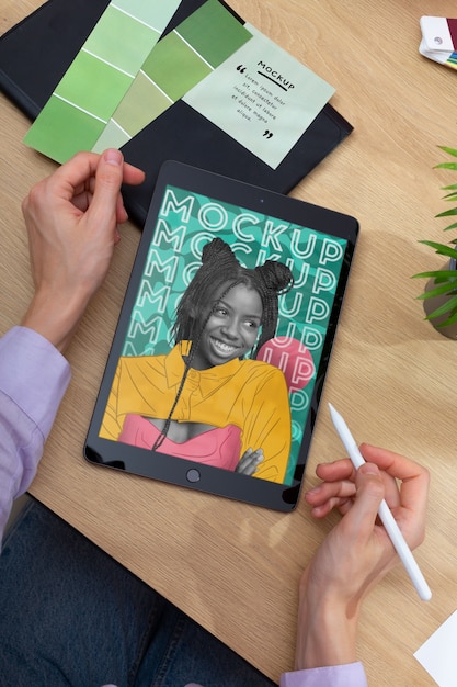 model holding tablet and pencil flat lay