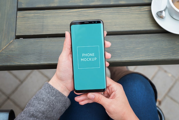 Modern smart phone mockup in woman hands close-up.