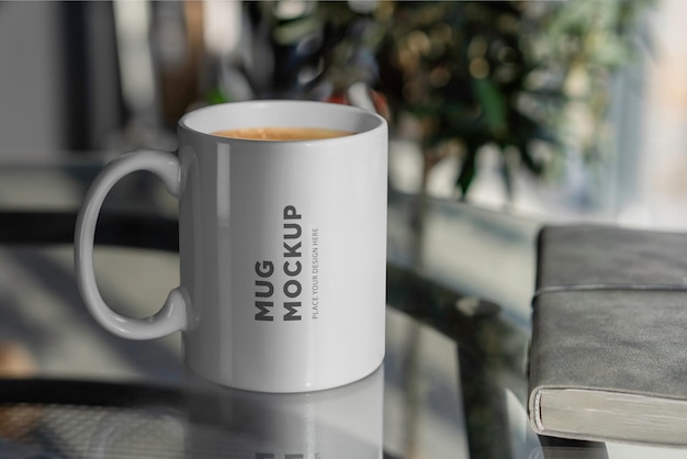 a mug on a glass table with a book