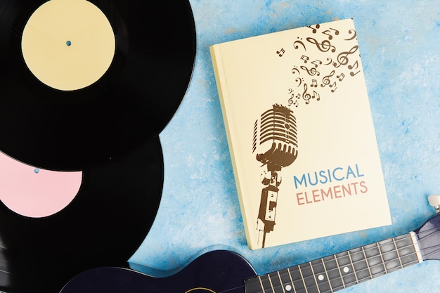 Libro di elementi musicali con chitarra in vinile e ukulele