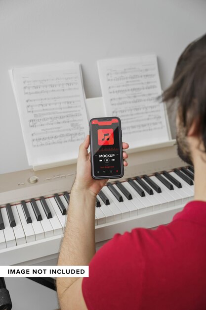 Uomo del musicista che tiene il modello dello smartphone