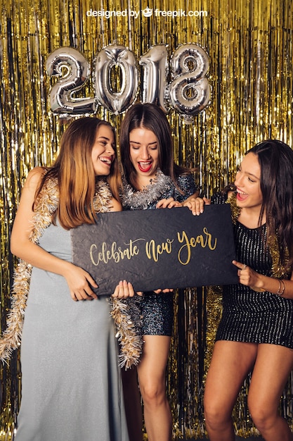 PSD nuovo anno mockup con tre ragazze in possesso di piccola scheda