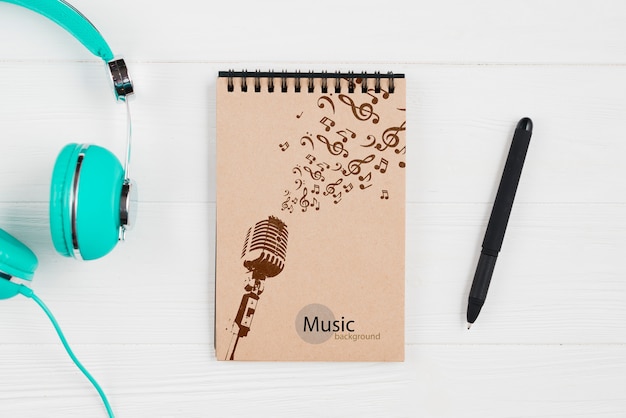 Notebook for music notes with headphones beside