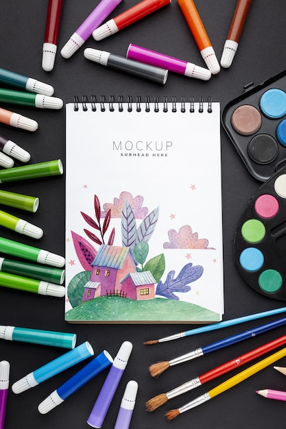 notebook with markers and brushes frame