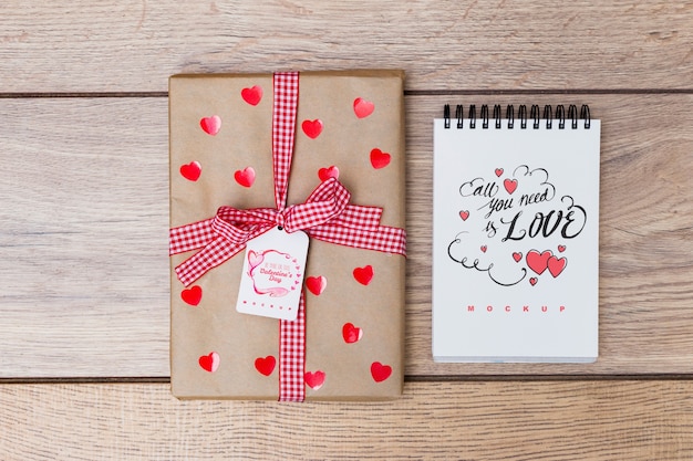 PSD mockup di blocco note accanto alla confezione regalo per san valentino