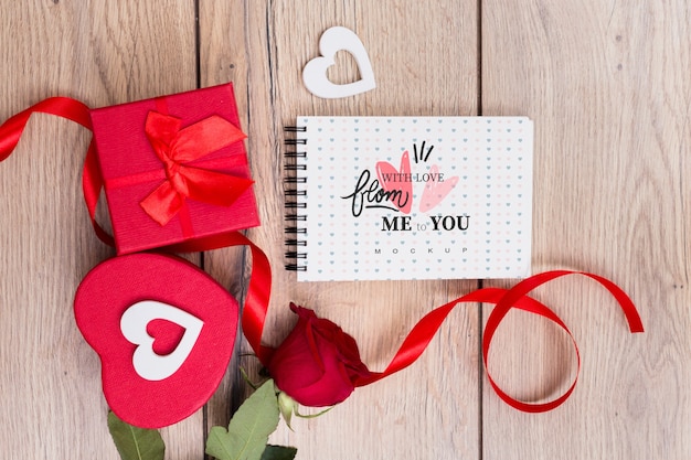 Mockup di blocco note accanto a scatole regalo per san valentino