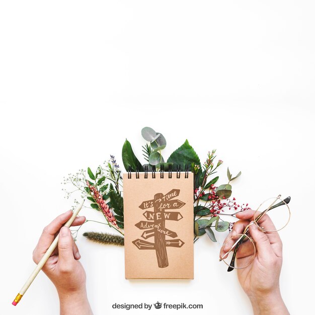 Notepad mockup with hands and leaves