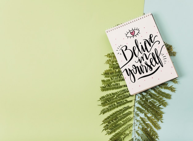 Mockup di blocco note con foglie tropicali