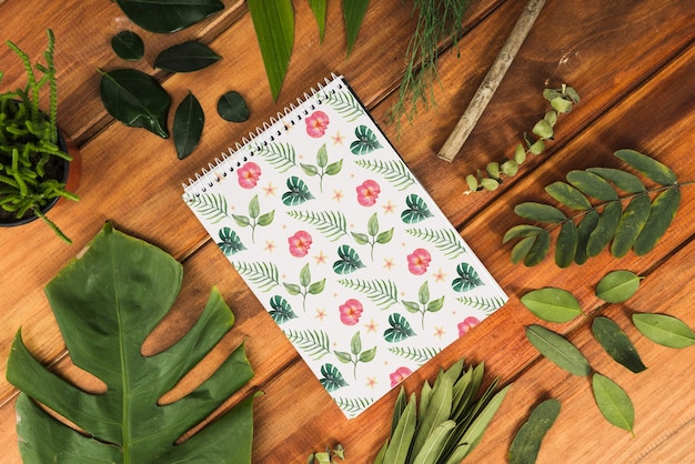 Mockup di blocco note con foglie tropicali