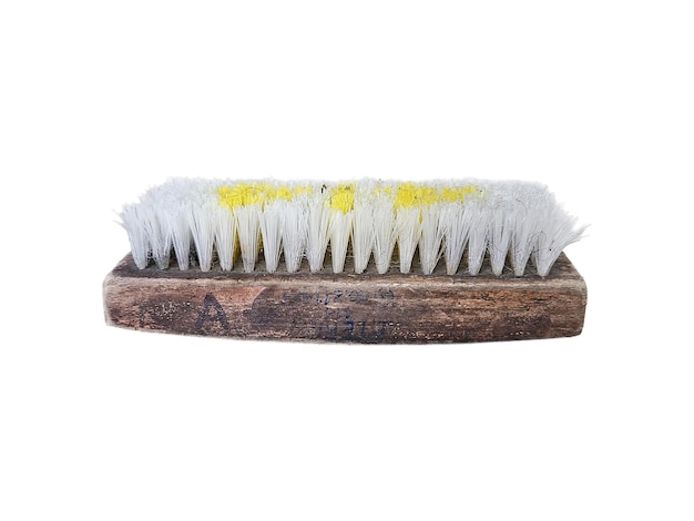 Old worn wooden clothes brush with white and yellow bristles