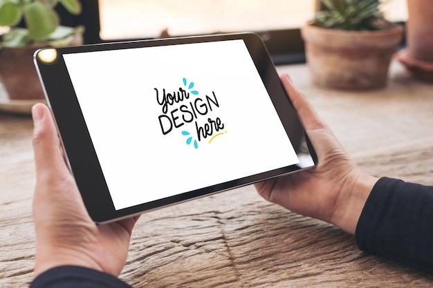 Osoba trzymająca tablet pokazujący projekt na ekranie