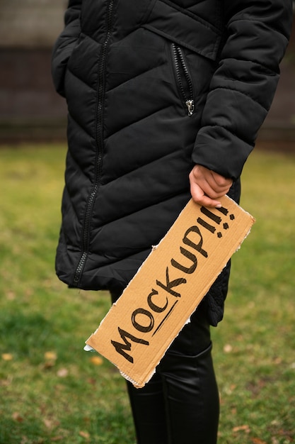 Osoba z makietą szyldu z recyklingu materiału