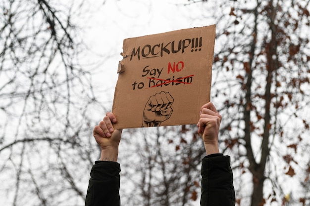Osoba z makietą szyldu z recyklingu materiału