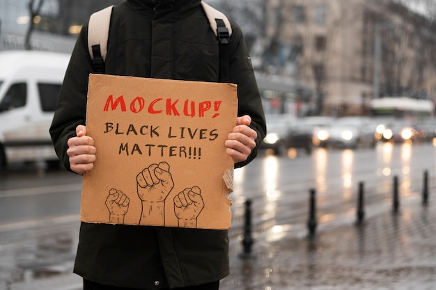 Osoba z makietą szyldu z recyklingu materiału