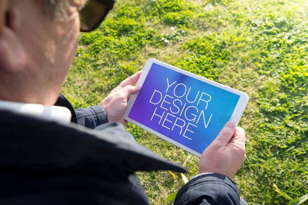 Oude man met tablet-mockup