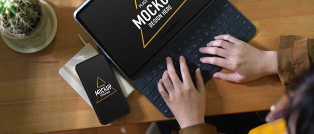 Overhead shot of female working with mock up digital tablet, smartphone and schedule book