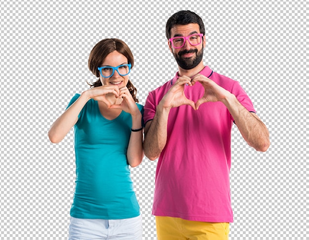 Paar in kleurrijke kleding die een hart met hun handen maken