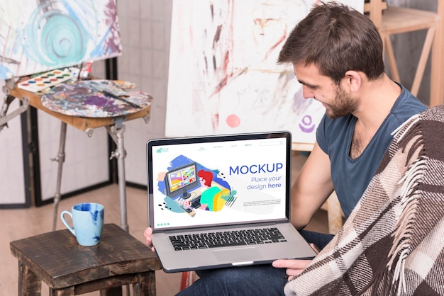 painter holding a laptop digital mock-up
