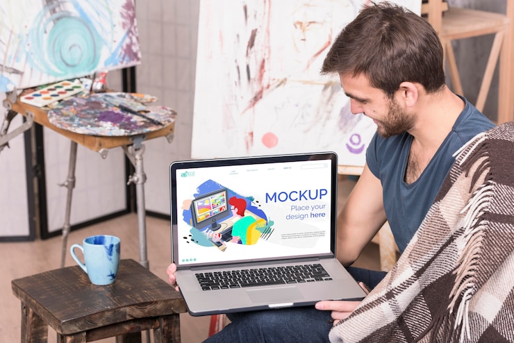 PSD painter holding a laptop digital mock-up