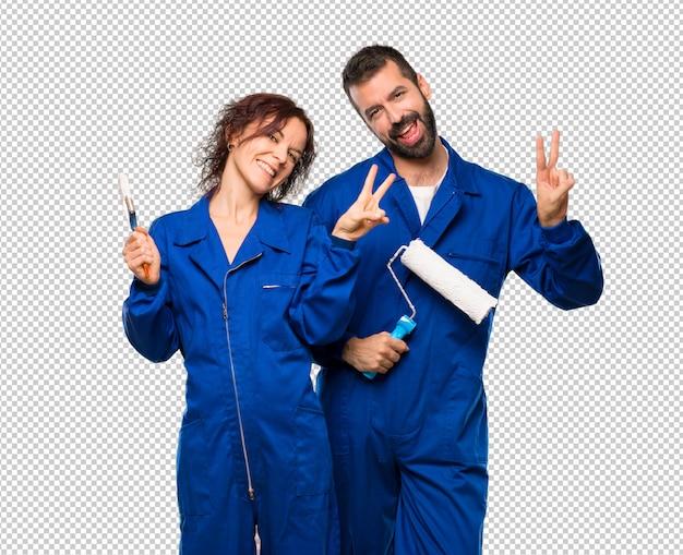 Painters smiling and showing victory sign with both hands