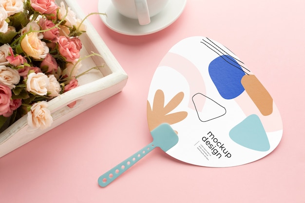 Paper mock-up hand fan with flowers bouquet and cup