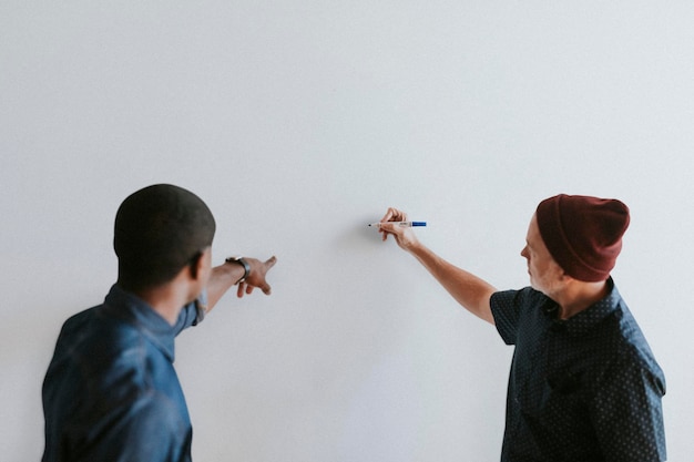 PSD persone che scrivono su un mockup di muro bianco