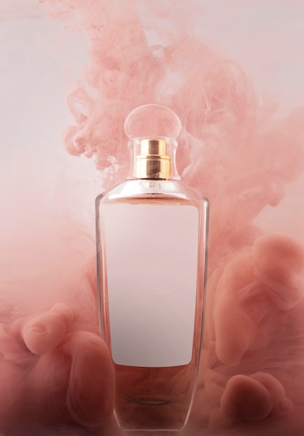 Bottiglia di profumo e fumo rosa