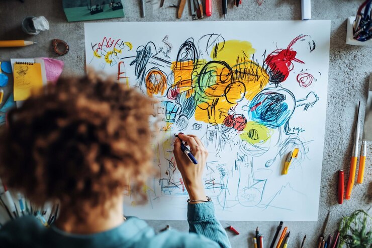 PSD person drawing colorful abstract art on large paper creative process
