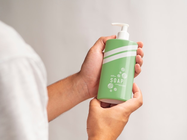 Person holding a liquid soap bottle mock-up