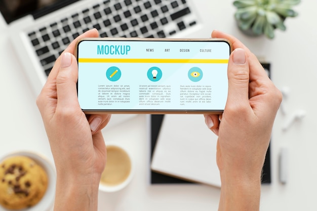person holding a mock-up smartphone