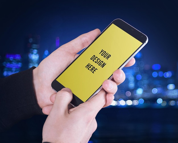 a person holding a phone with a yellow screen that says your design here mockup psd