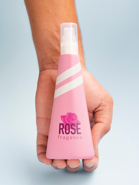 Person holding pink fragrance bottle mock-up